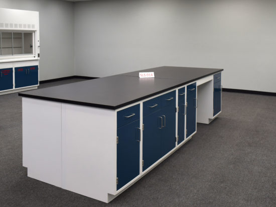 Laboratory island with desk area and black countertop.