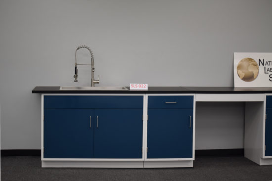 Blue laboratory cabinets with black countertops and two desks.