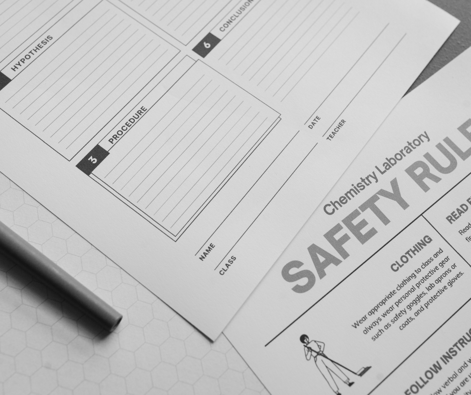 A black-and-white close-up image of laboratory documents placed on a table. The documents include a chemistry laboratory worksheet with sections labeled "Hypothesis," "Procedure," and "Conclusion," with lines for writing notes.