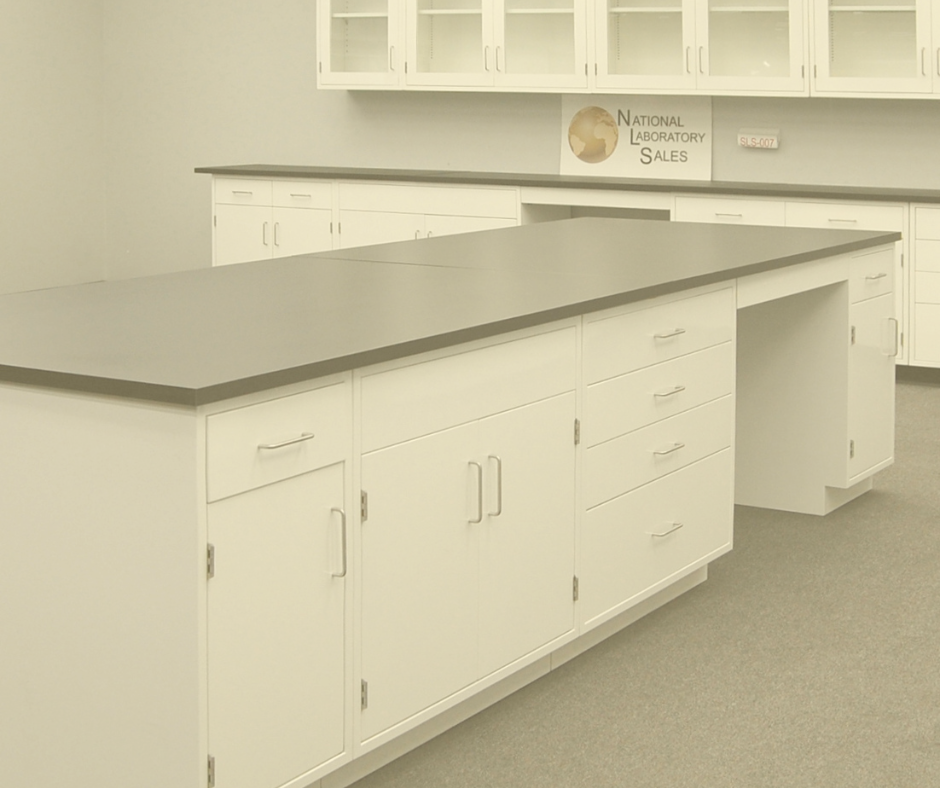 Modern laboratory workspace featuring white cabinetry with drawers and cupboards, black epoxy resin countertops, and wall-mounted glass-front storage cabinets.